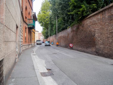 Cremona, İtalya 16 Eylül 2025 Suzuki Vitara ve Fiat Strada araçları eski tuğladan bir duvarla dar bir şehir sokağında yol işaretleri göstererek tarihi bir yolda 30 derece hız sınırı koyuyorlar.
