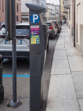 Cremona, İtalya 16 Eylül 2025 Easypark parkmetresi bir İtalyan caddesinde duruyor. Belirlenmiş mavi çizgilere park etmiş arabaları gösteriyor. Buna 2023 model Toyota Yaris Cross hibrit SUV ve Peugeot da dahil.