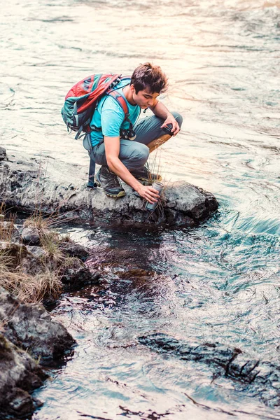 Jonge Zwerver Tapt Zuiver Water Uit Een Rivier Mok Hij — Stockfoto