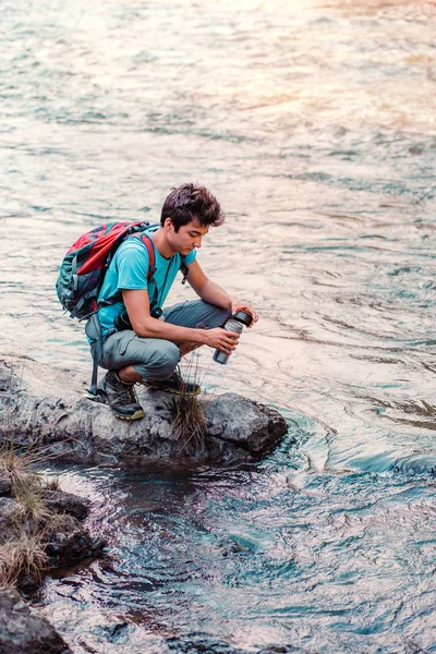 Jonge Zwerver Tapt Zuiver Water Uit Een Rivier Mok Hij — Stockfoto