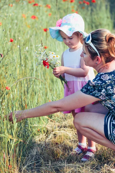 母亲和她的小女儿在野花地里 — 图库照片