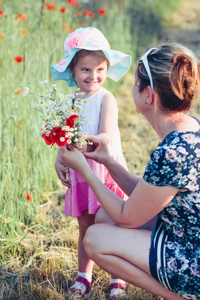 Madre y su pequeña hija en el campo de las flores silvestres —  Fotos de Stock