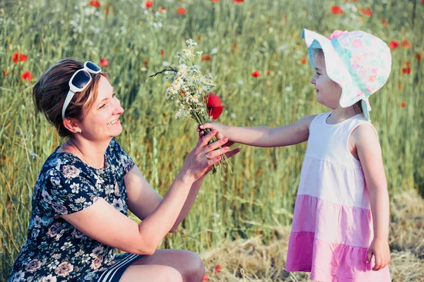 Madre y su pequeña hija en el campo de las flores silvestres —  Fotos de Stock