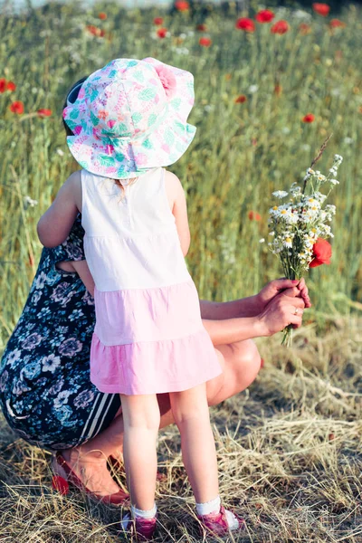 Madre y su pequeña hija en el campo de las flores silvestres —  Fotos de Stock