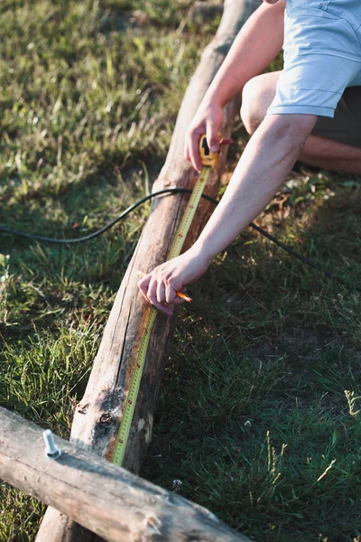 Man using steel tape measure to measuring of timber while workin — Stock Photo, Image