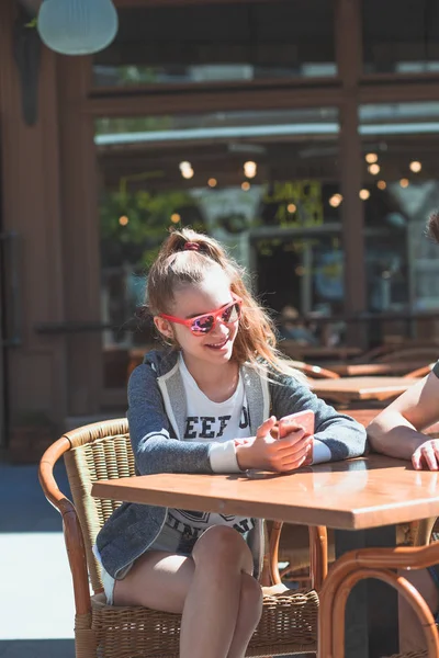 Genç kadın ve adam Kaldırım Café konuşuyor ve kullanarak m oturan — Stok fotoğraf