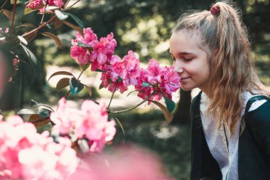 Bahçede güzel pembe kokulu kapalı gözleri ayakta kız