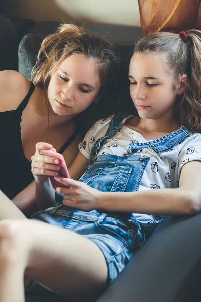 Mujeres jóvenes usando teléfonos móviles viendo clips de música, mensajes de texto, yo — Foto de Stock