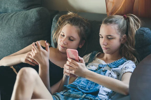 Jonge vrouwen met behulp van mobiele telefoons kijken naar muziek clip, sms 'en, mij — Stockfoto