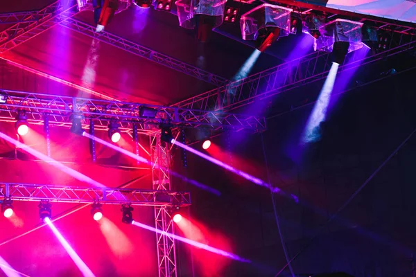Spotlights, red and blue beams of lights above stage during conc