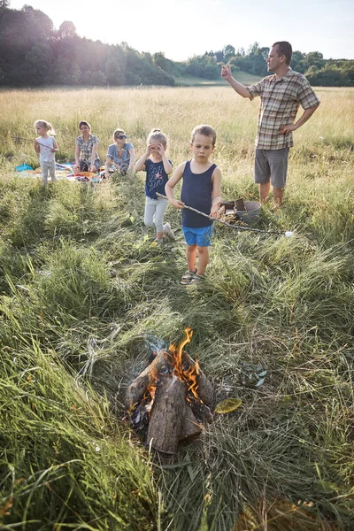 Liten pojke rostning marshmallow över en lägereld — Stockfoto