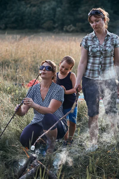 Women roasting a marshmallows over a campfire — Stock Photo, Image