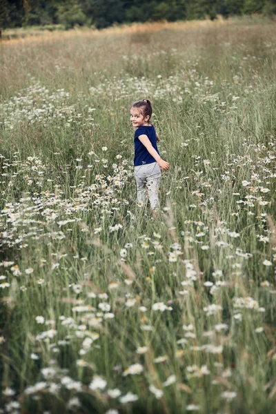 Petite fille heureuse jouant dans une grande herbe — Photo