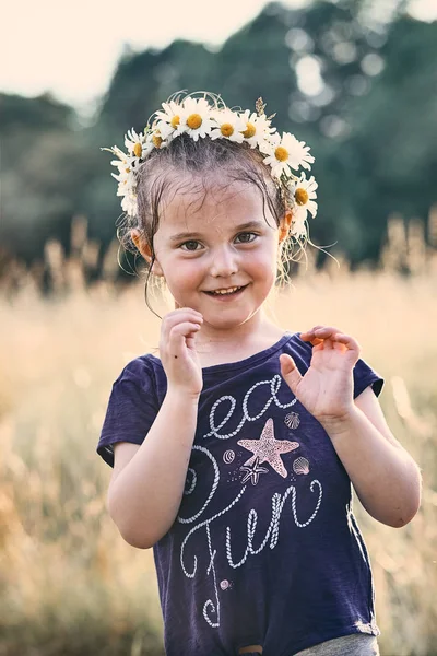 Petite fille portant une couronne de fleurs sauvages sur sa tête — Photo