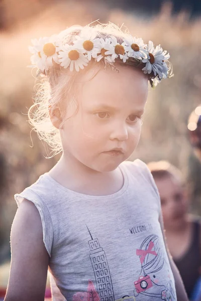 Маленька дівчинка в короні диких квітів на голові — стокове фото