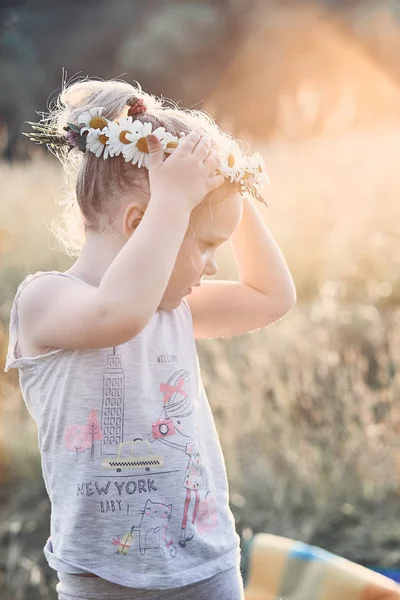 Holčička nosí na hlavě korunku divokých květin. — Stock fotografie