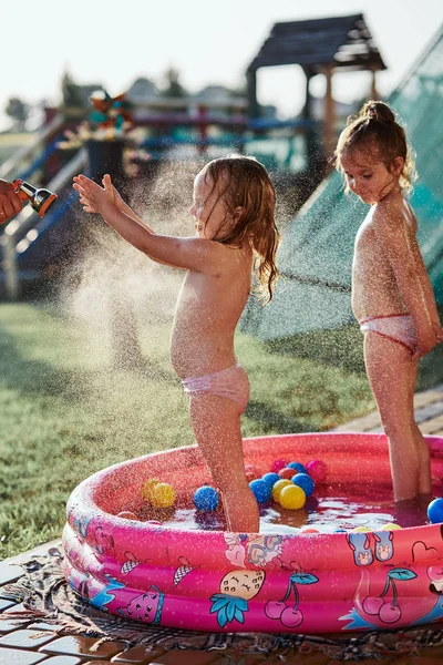 Küçük kızlar zevk bir serin su spreylenmiş tarafından onların baba — Stok fotoğraf