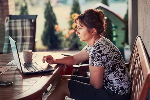 Mujer trabajando en casa, usando un ordenador portátil — Foto de Stock