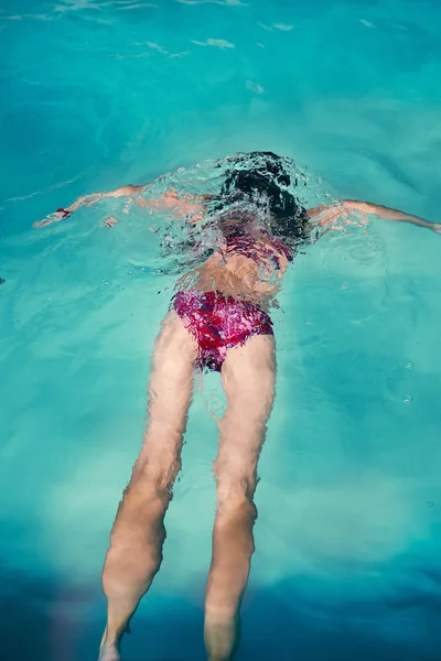 Flicka simma och koppla av i poolen — Stockfoto