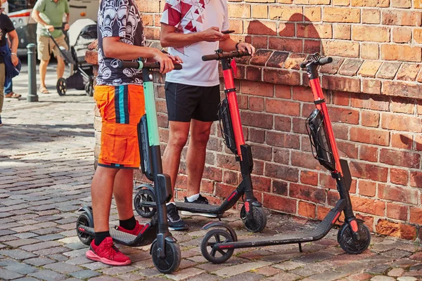 Twee mannen huren elektrische scooters met behulp van huur service op SmartPhon — Stockfoto