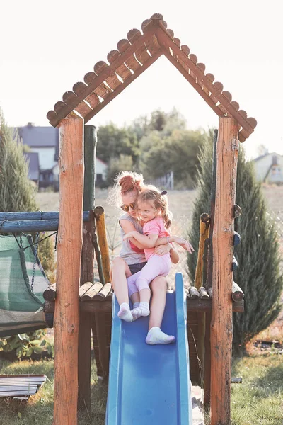 Sisters having fun on a slide together — Stock Photo, Image