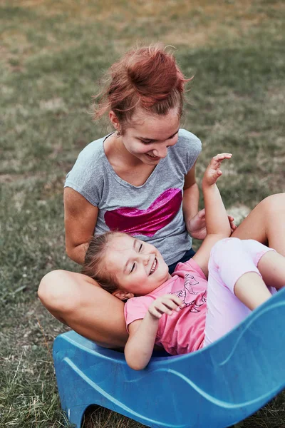 Hermanas divirtiéndose en una diapositiva juntas —  Fotos de Stock