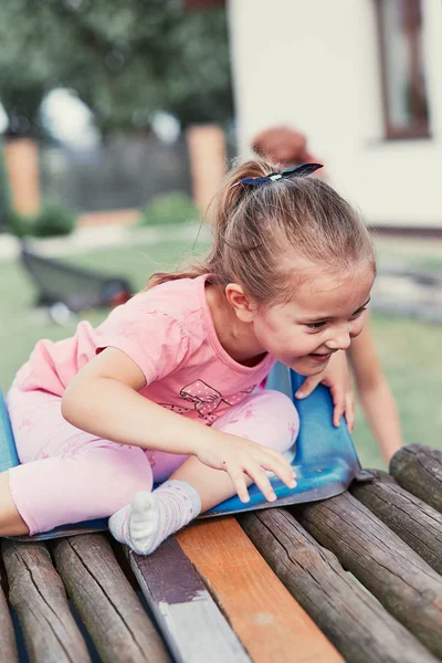 Liten flicka som leker i en hem lekplats i en bakgård — Stockfoto