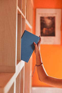 Genç kız kütüphanede kitap arıyor