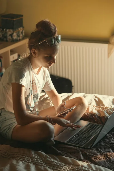 Jonge vrouw met draagbare computer en mobiele telefoon — Stockfoto