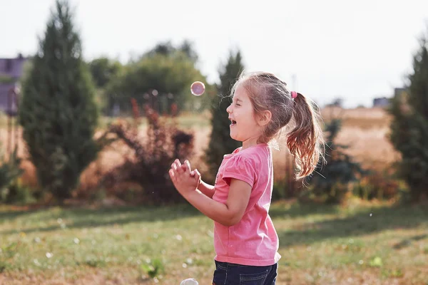 Маленькая девочка играет с мыльными пузырями — стоковое фото