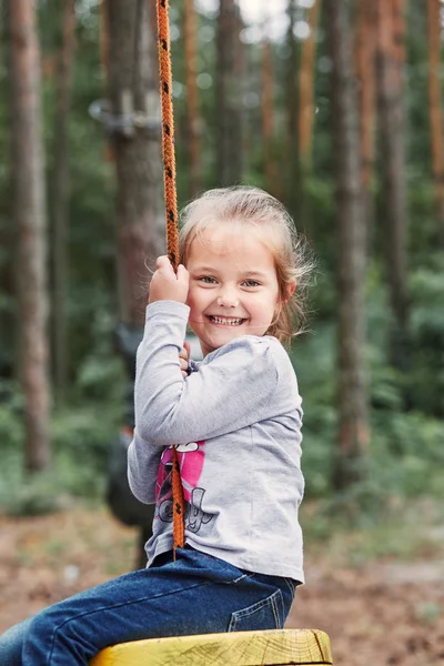 Šťastná dívka jezdila na zip v lanové parku — Stock fotografie