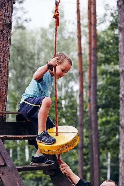 Glücklicher Junge reitet auf der Seilrutsche im Seilpark — Stockfoto