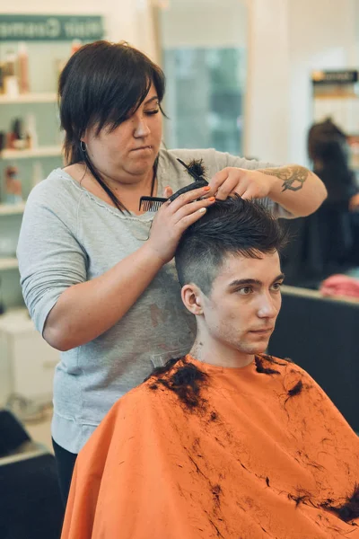 Hairdresser is haircutting styling young mans hair — Stock Photo, Image