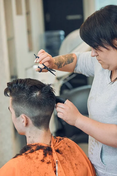 Hairdresser is haircutting styling young mans hair — Stock Photo, Image