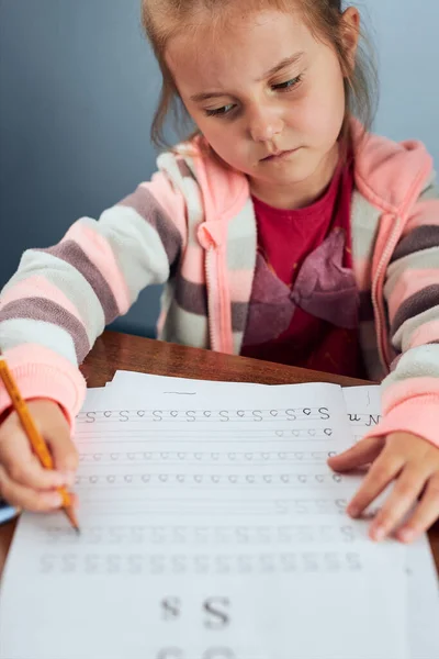 少女の未就学児しぶしぶ手紙を書くことを学ぶ 子供の手紙を書く 不本意ながら学校の仕事をする 早期教育の概念 — ストック写真