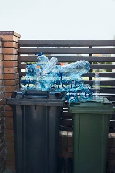 Disposal containers with empty used plastic water bottles on the top. Collecting plastic waste to recycling. Concept of plastic pollution and too many plastic waste. Environmental issue