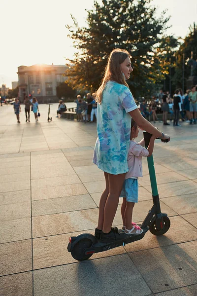 Tiener Meisje Haar Zus Kleuter Rijden Een Elektrische Scooter Het — Stockfoto