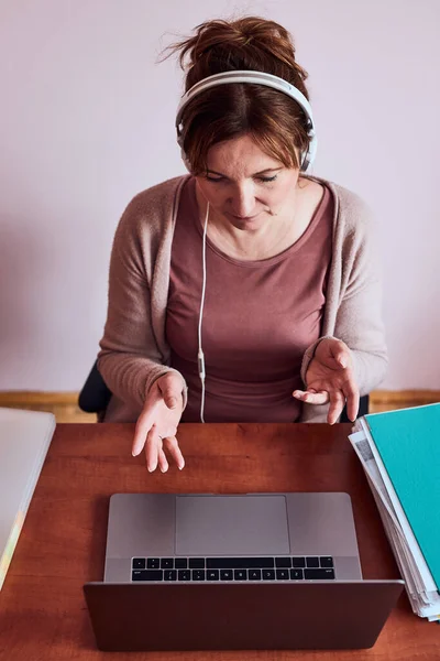 Konuşan Bir Kadın Evinden Laptopla Yaptığı Görüntülü Konuşma Sırasında Işini — Stok fotoğraf