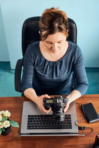 女摄影师在笔记本电脑和相机上拍摄照片 妇女编辑整理浏览照片工作时作为自由职业者坐在办公桌前 — 图库照片