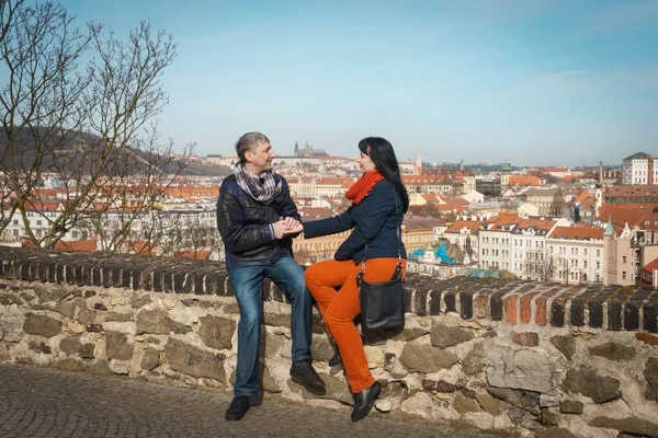 Bir erkek ve bir kadın el ele tutuşup Višegrad gözlem güvertesinde oturuyorlar..