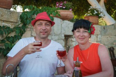 Yetişkin bir çift restoranda yemek yer ve şarap içer..