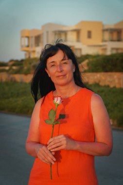 Kırmızı elbiseli bir kız ve tek bir gül.