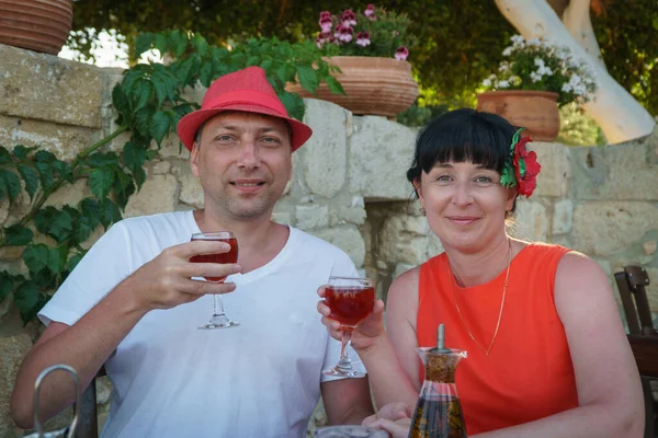 Yetişkin bir çift restoranda yemek yer ve şarap içer..