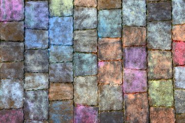 Texture of paving slabs in different colors of chalk. ulticolored background of a painted footpath.