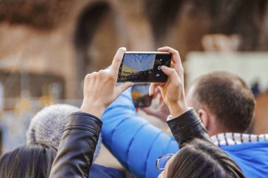 Roma'da bina Colosseum stadyumda fotoğraf çekimi smartphone tutan el