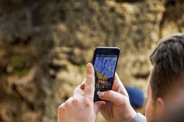 Hand holding smartphone taking picture in Colosseum stadium building in Rome — Stock Photo, Image