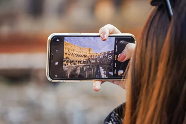 Ruka držící smartphone vyfotit v Koloseu stadion v Římě — Stock fotografie