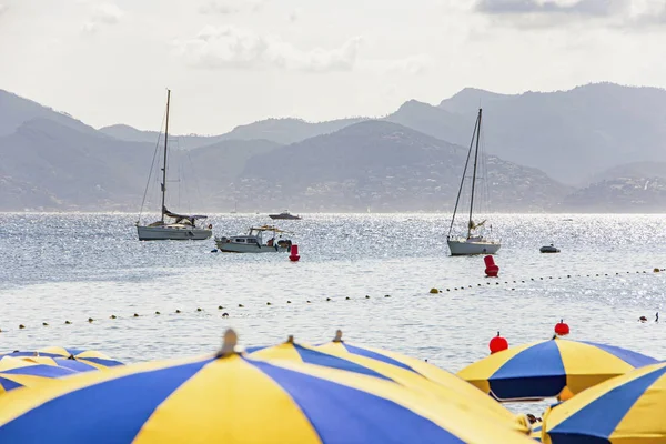 Zatoka morska z jachtami łodzi i parasolem plażowym w Cannes — Zdjęcie stockowe