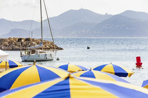 Mořská zátoka s jachty a plážovým deštníkem v Cannes — Stock fotografie