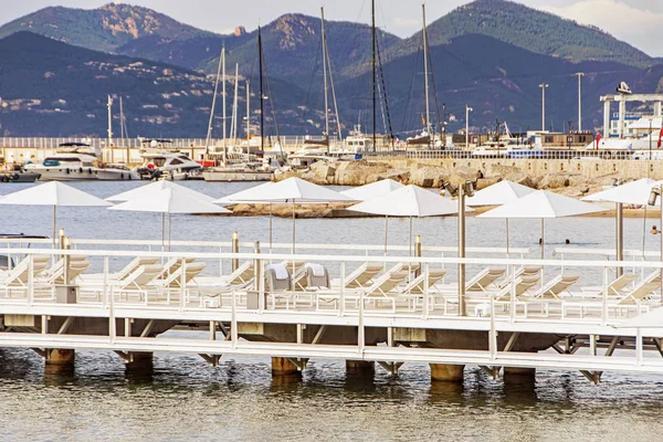 Zatoka morska i molo z jachtami łodzi i parasolem plażowym w Cannes — Zdjęcie stockowe